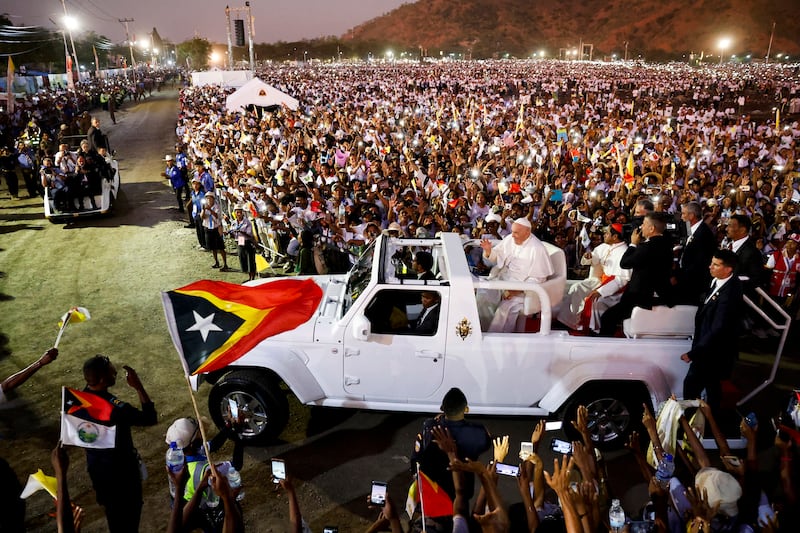 Pope Francis waves as he's driven through a crowd of estimated 600,000 people after presiding over a mass in the seaside park of Tasitolu near Dili, Timor-Leste, Sept. 10, 2024.